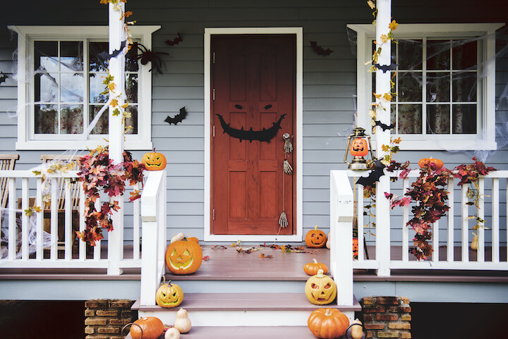 Eingangsbereich von Haus mit Halloweendekoration, geschnitze Kürbisse am Boden