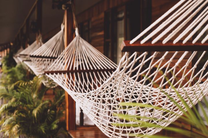 Eine Hängematte aus Netz auf einer Terrasse mit vielen Holzelementen